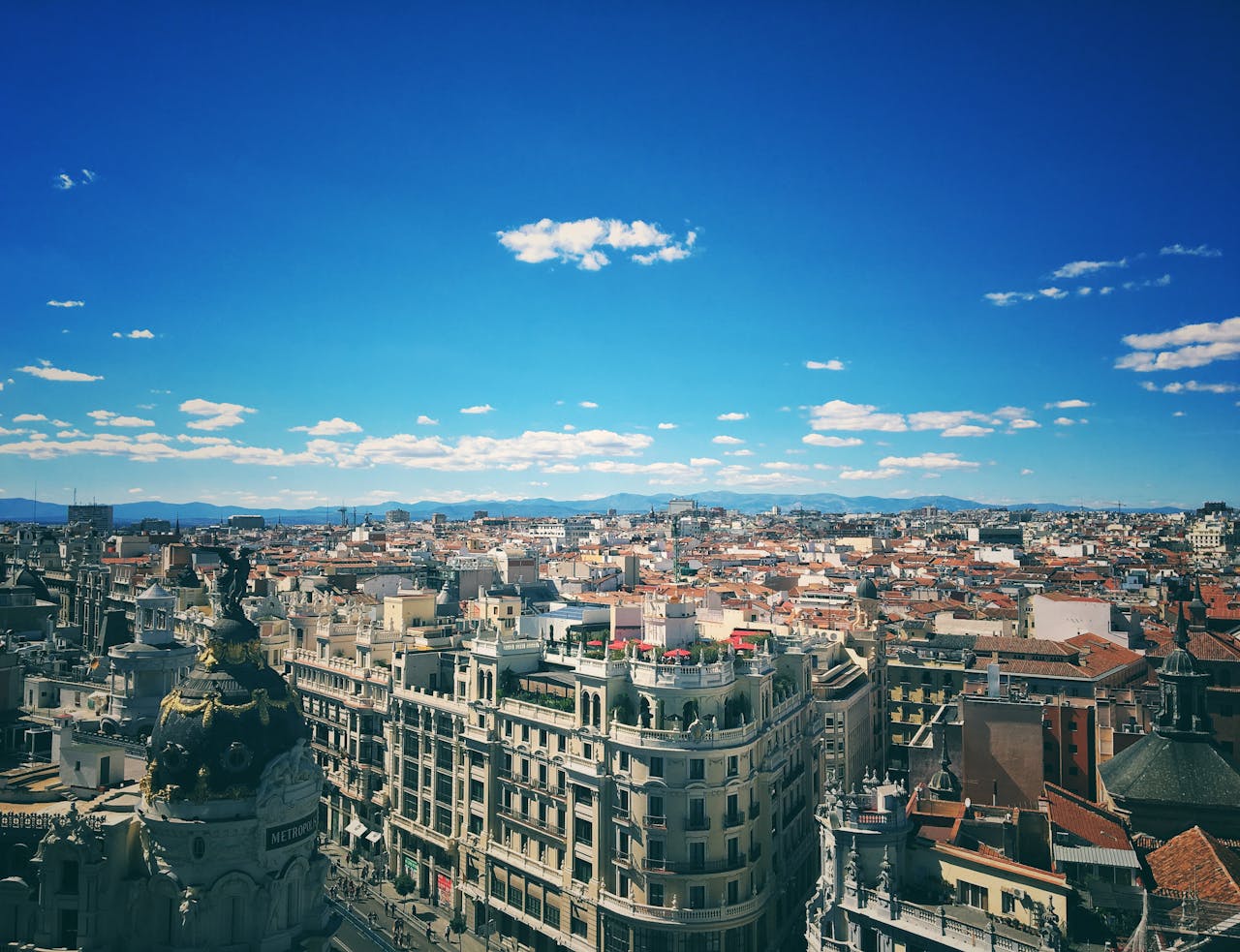 Madrid travel guide: Panoramic view of Madrid's historic and modern cityscape under a clear blue sky.