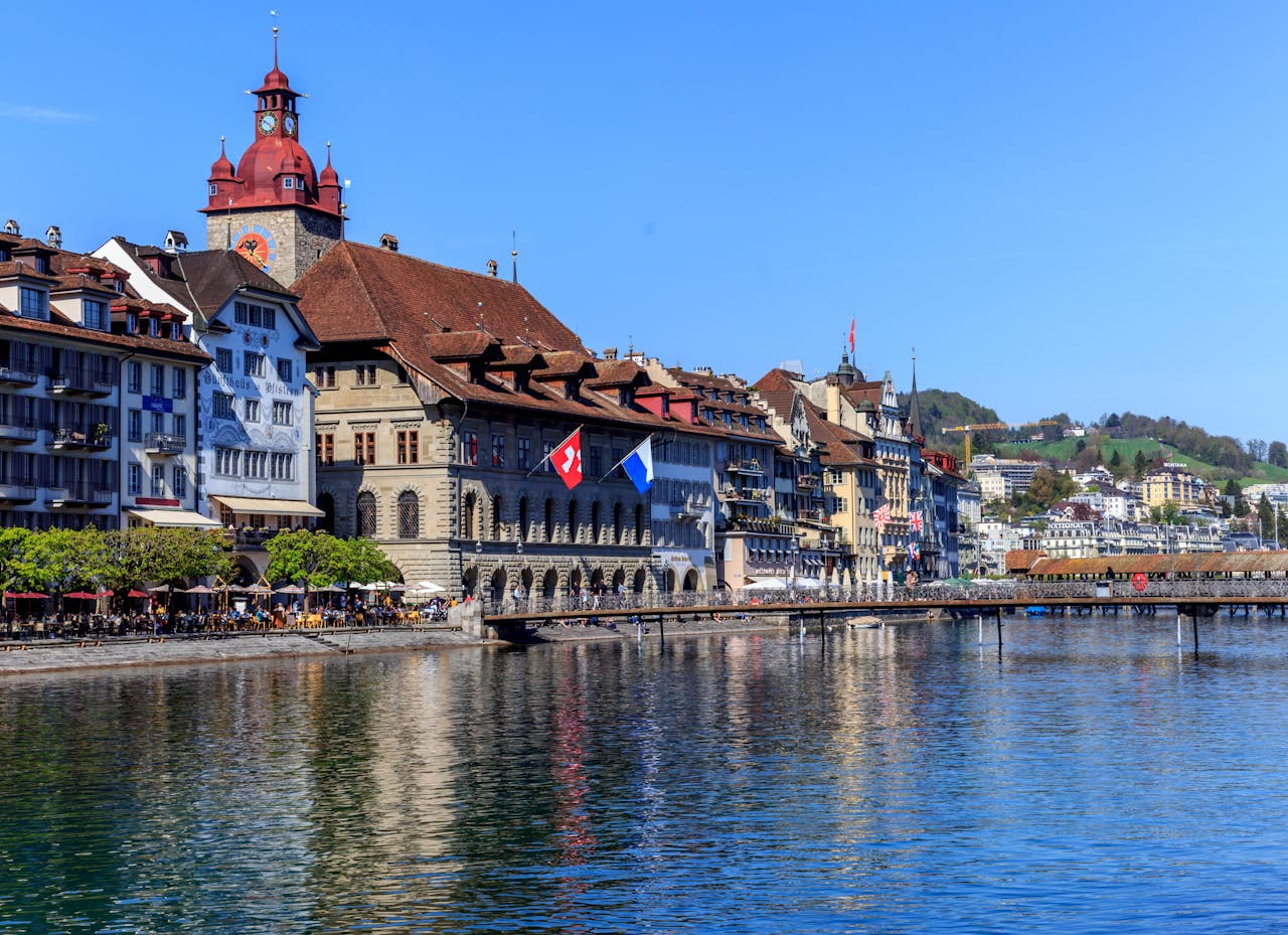 The scenic view of Luzern's historic waterfront, featuring the iconic Kapellbrücke and traditional Swiss architecture along the serene Lake Luzern.